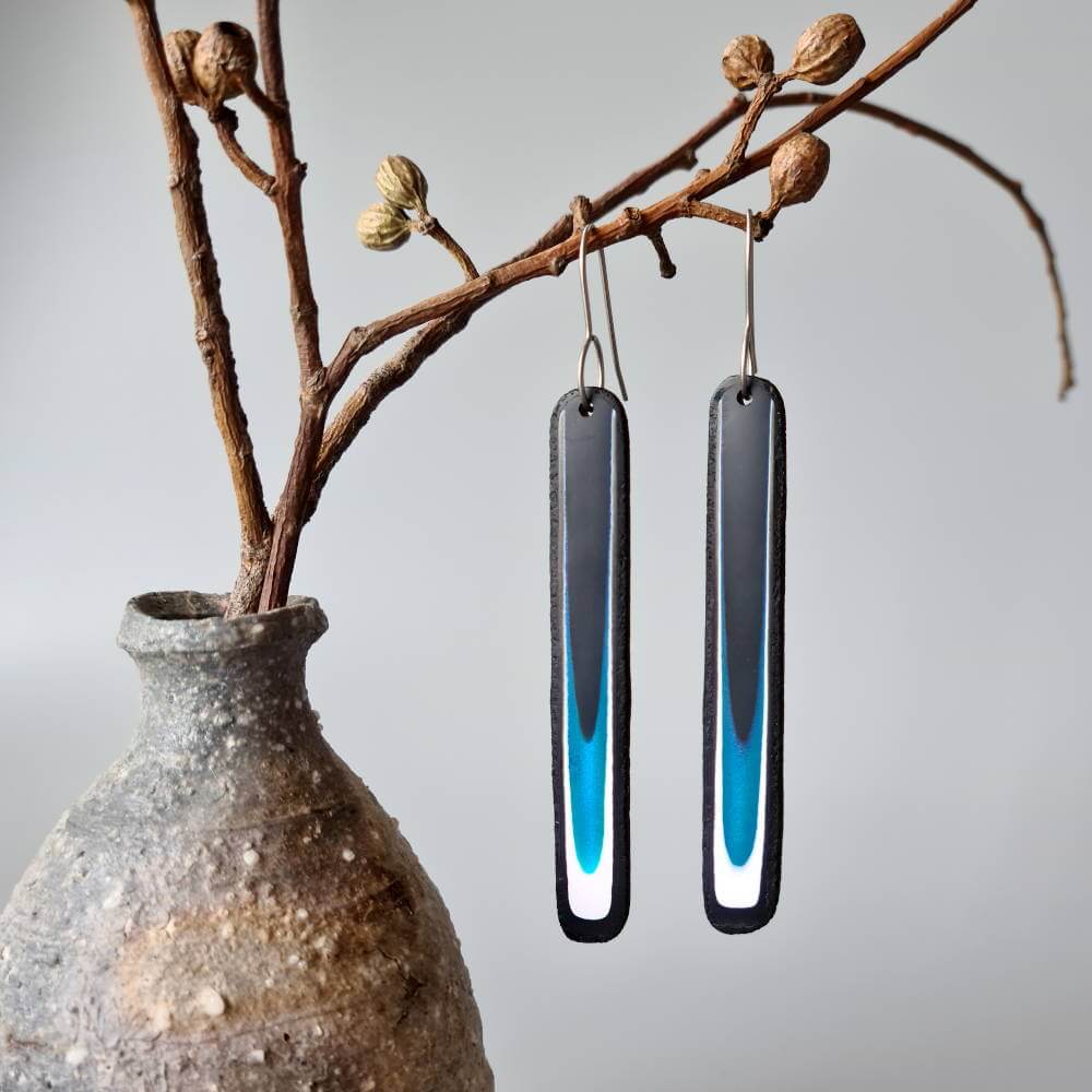 Handmade long dangle earrings with a clean, modern pattern in black, teal blue and white. Hand crafted titanium earwires.