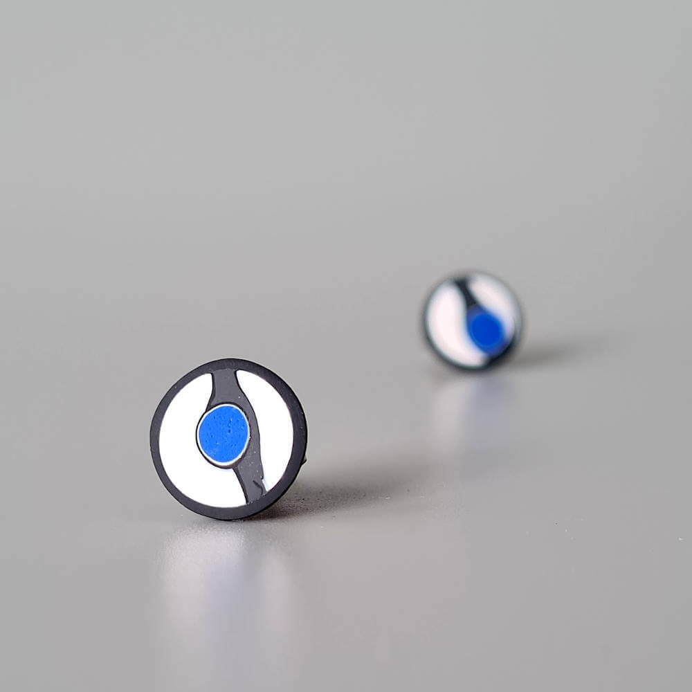 Handmade stud earrings with asymmetrical abstract flower bud pattern in blue tones, on a white background with a charcoal border. Titanium posts.