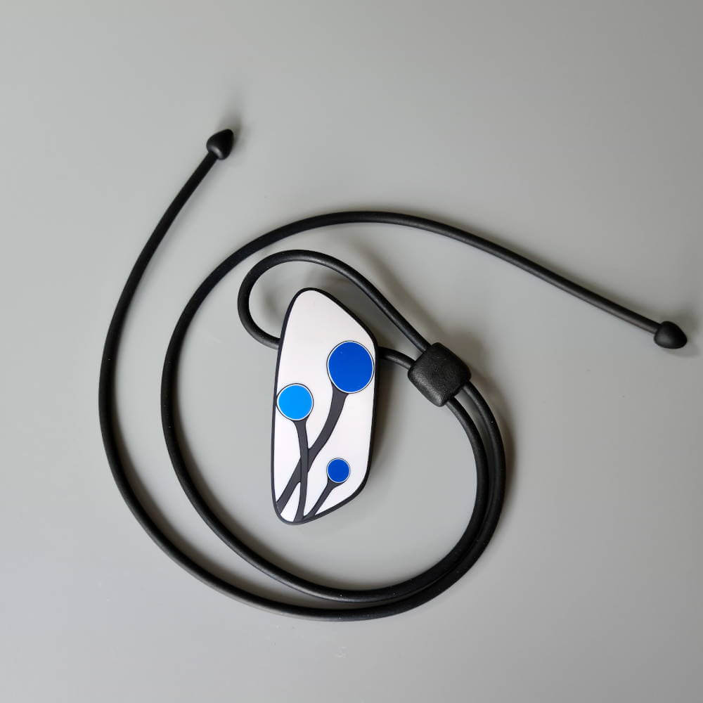 Handmade shield shaped necklace featuring an abstract flower bud motif in blue on a white background, with charcoal border. It is approximately 2.6 cm wide and 6.4cm long and hangs on a black adjustable cord.